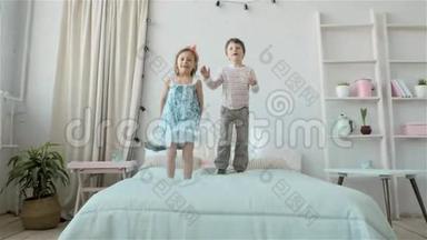 孩子们在床上蹦蹦跳跳的肖像，小男孩和小女孩的兄妹玩得开心，笑得开心